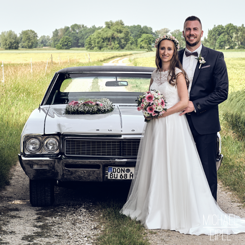 Brautpaar vor Hochzeitsauto – Hochzeitsfotografie